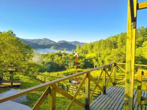 a wooden deck with a view of a valley at Villa Pitanga Pousada in São Martinho