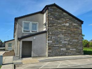 a brick house with a garage at Garden House Rooms in Kirkwall