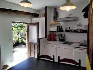 a kitchen with white cabinets and a counter top at Maison de la Source in Leychert