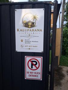 a sign with a no parking sign in front of a building at Kalupahana Villa in Beruwala