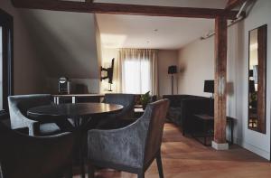 a living room with a table and chairs at Havn Hotell og Restaurant in Skudeneshavn