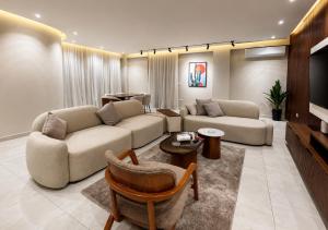 a living room with two couches and a tv at Spacious 3BR Apartment in Prime Sheikh Zayed in Sheikh Zayed
