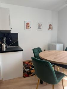 a dining room with a table and chairs and a kitchen at Przy Żelaznym Moście in Kłodzko