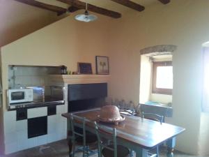 a dining room with a table and a microwave at La casita marrón in Palafrugell
