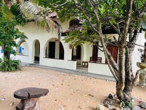 a wooden bench sitting in front of a building at Hakkeem's Homestay in Arugam Bay +7 photos