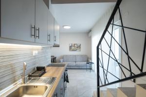 a kitchen with a sink and a couch in a room at EriZen Jacuzzi suites in Keramoti