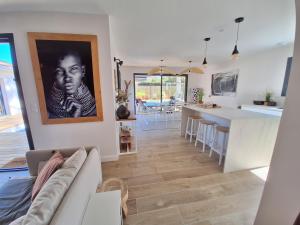 a living room and kitchen with a black and white photo on the wall at Villa Céline - Prestige, Piscine & Jacuzzi in Vielle-Saint-Girons +14 photos