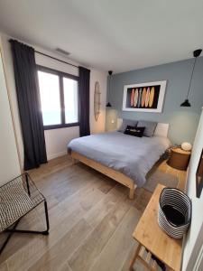 a bedroom with a large bed and a table at Villa Céline - Prestige, Piscine & Jacuzzi in Vielle-Saint-Girons