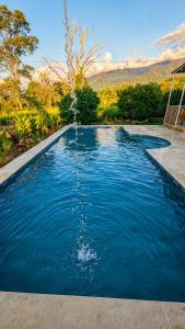 a swimming pool with a fountain in the middle at Casa Jaguar Viotá in Viotá