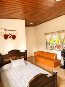 a bedroom with a bed and a chair and a window at Casa Jaguar Viotá in Viotá +23 photos