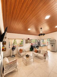 a living room with couches and a wooden ceiling at Casa Jaguar Viotá in Viotá