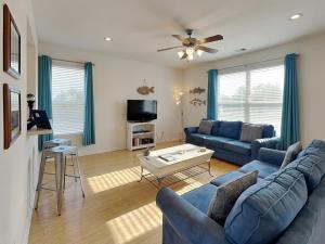 a living room with a blue couch and a table at Sandy Hook in Galveston