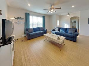 a living room with two blue couches and a tv at Sandy Hook in Galveston