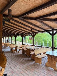 a group of wooden tables and benches in a pavilion at Vuk Etno domaćinstvo in Barajevo
