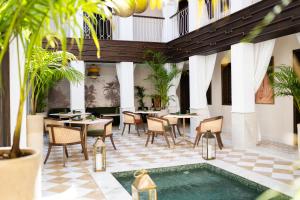 a courtyard with tables and chairs and a pool at Riad Le Saadien ,Adult only in Marrakesh