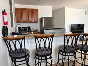 a kitchen with four bar stools in front of a counter at josedith'sweet house in Isabela
