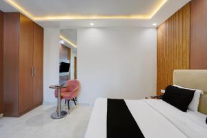 a hotel room with a bed and a chair at Hotel O by OYO S R Galaxy in Kānpur +30 photos