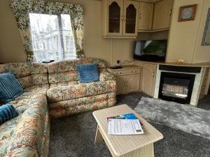 a living room with a couch and a table at 48 River View in Dunoon