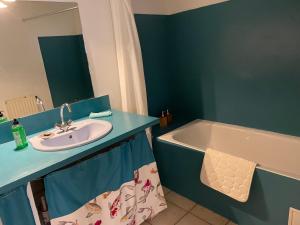 a bathroom with a sink and a bath tub at Sand Home in Le Puy-en-Velay