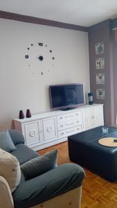 a living room with a tv on a white entertainment center at A parada da Ribeira in Ourense +21 photos
