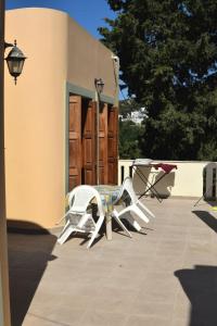a table and chairs on a patio in front of a building at Το περασμα in Panormos Kalymnos +2 photos