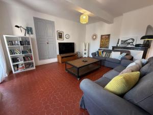 a living room with a couch and a table at Le Balcon des Pourcelles in Les Mées