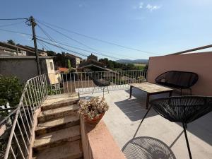 a balcony with stairs and a table and chairs at Le Balcon des Pourcelles in Les Mées