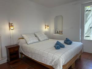 a bedroom with a bed with two blue towels on it at Le Balcon des Pourcelles in Les Mées