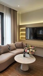 a living room with a couch and a table with flowers at Annava Hotel & Coffee in Hai Phong