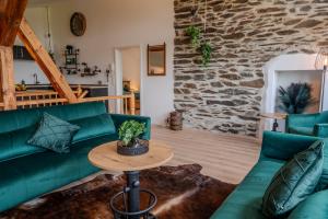 a living room with a green couch and a table at Starkenburger Perle in Starkenburg