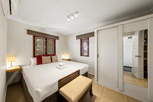 a bedroom with a large white bed and a window at Atlantis Beach House in Willemstad +48 photos