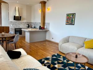 a living room with a couch and a table at Appartement 93m2 Cosy - 2 chambres in Wimmenau +8 photos