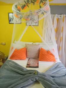 a bed with a canopy and pillows in a room at Movement and Reposé in Clarks Town +33 photos