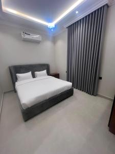a bedroom with a bed and a large window at شقق فاخرة in Mahlal