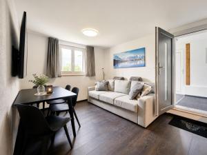 a living room with a couch and a table at Clarke's Lakeside Chalet 1 in Leissigen