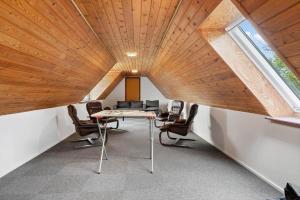 an attic office with a table and chairs in a room at 80324-Ulfborg-Munkhulevej-6 in Staby