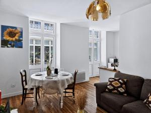 a living room with a table and a couch at Le Citadin - Centre - Wifi - Balcon in Dax