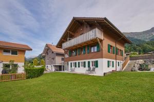 a large house with a large lawn in front of it at Clarke's Lakeside Chalet 1 in Leissigen