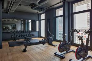 a gym with several tread machines in a room with windows at Locke at East Side Gallery in Berlin