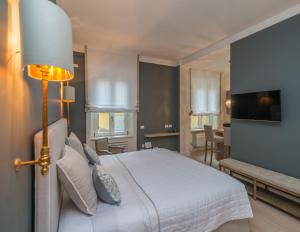 a bedroom with a large white bed and a television at Brera Luxury Suite in Milan