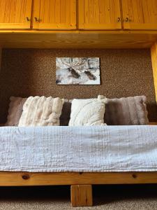 a bed with blankets and pillows on a shelf at Riviera Lodge II in Allos