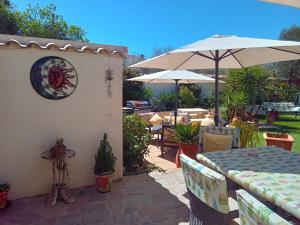 a patio with a table and an umbrella at Cortijo Esquina B&B Guesthouse in Arboleas