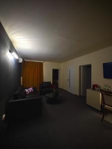 a living room with a couch and a table at Hotel Malvina in Sînnicolau Mare