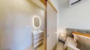 a small bathroom with a sink and a bed at Lobster Room - Estrela do Mar - 1 in Albufeira
