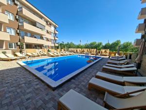 a swimming pool with lounge chairs next to a building at Apartment with pool in Veliko Gradište