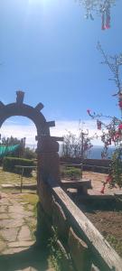a bench in a park with a view of the ocean at TAQUILE LODGE Perú in Huillanopampa