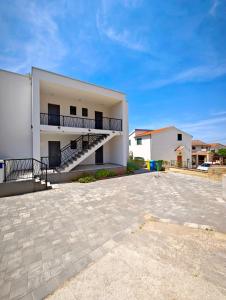 a large white building with a parking lot at Providenca Residence Šibenik in Šibenik
