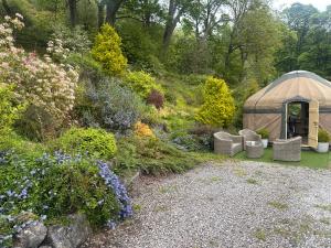 a gazebo in the middle of a garden at Thistlebank Yurt in Llangollen