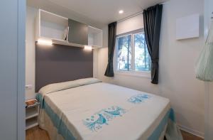 a small bedroom with a bed and a window at Camping Iscrixedda in Lotzorai