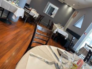 a dining room with a table with silverware on it at Logis Hotel Restaurant l'Amandois in Saint-Amand-Montrond